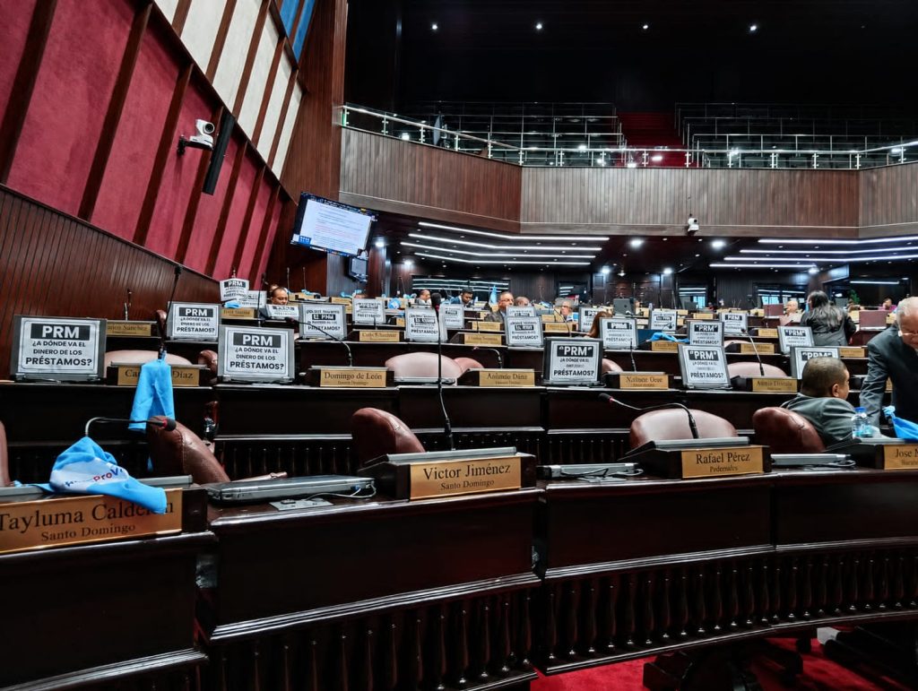 Fuerza del Pueblo protesta con carteles en la Cámara de Diputados durante debate de préstamos por US$465.5 millones